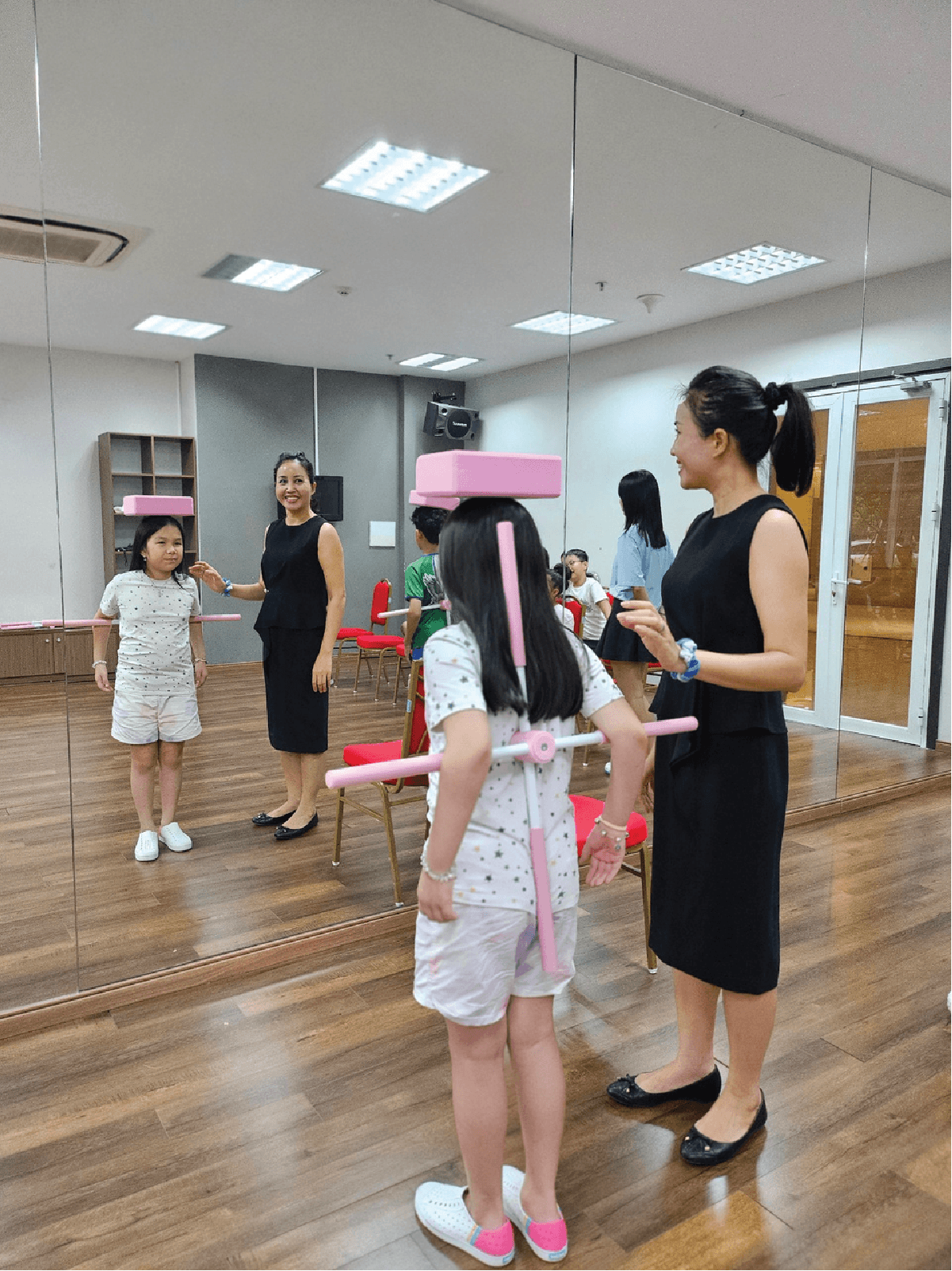 Giảng viên hướng dẫn trẻ luyện dáng đứng