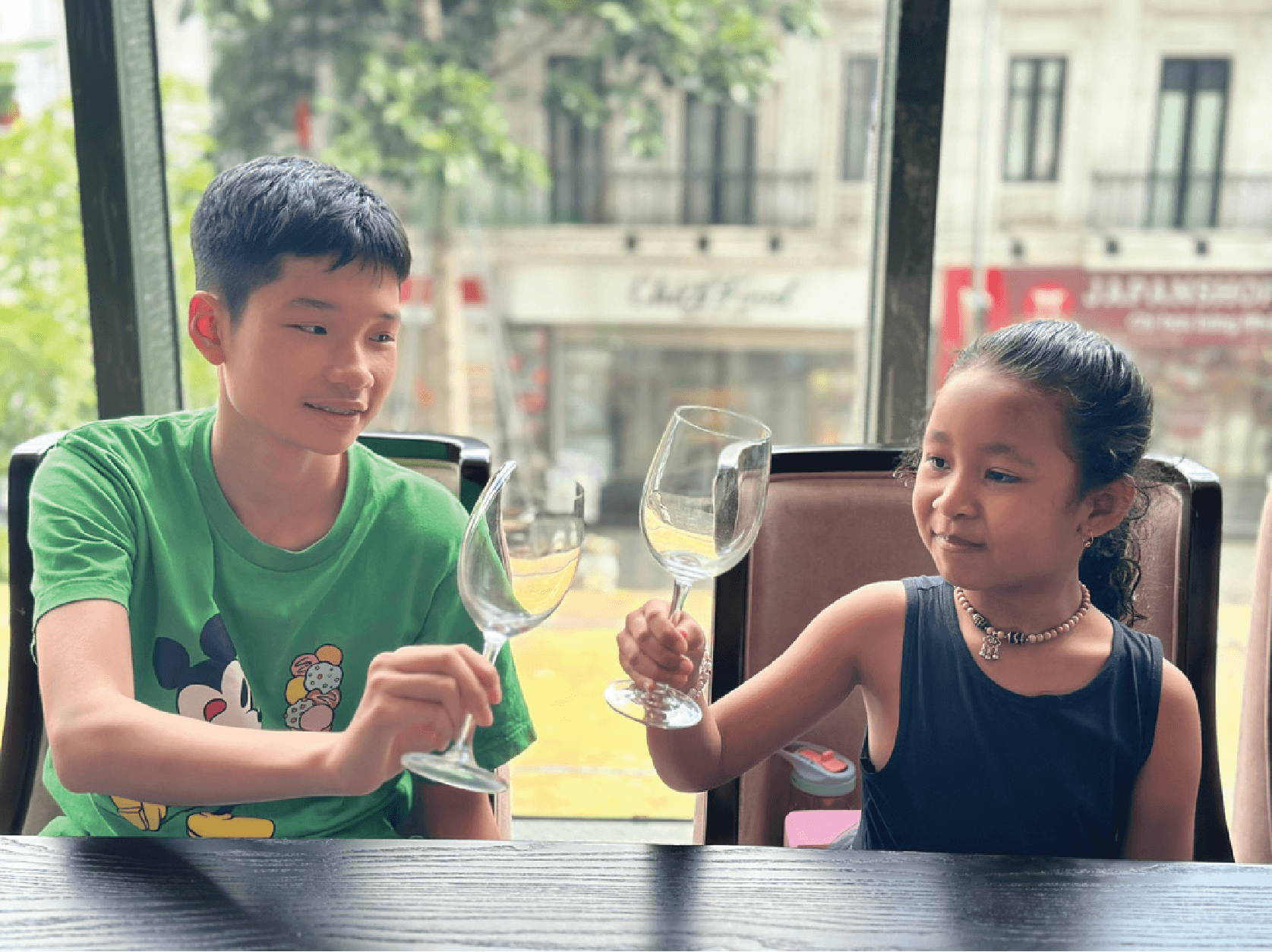 Hai học viên thực hành phép lịch sự tại bàn ăn
